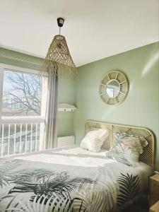 um quarto com uma cama, um espelho e uma janela em Beau duplex familial avec jardin clôturé em Douvaine