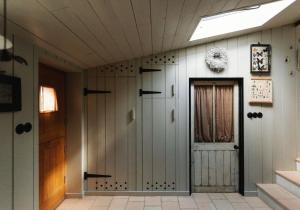 a hallway with a door in a house at Spinks Nest - a boutique cottage near Holt, North Norfolk in Hunworth +67 photos