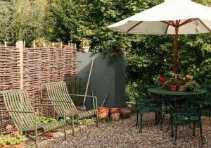 a table and chairs and an umbrella in a garden at Spinks Nest in Hunworth