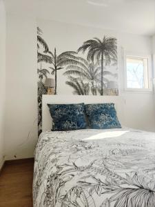 um quarto com uma cama com palmeiras na parede em Beau duplex familial avec jardin clôturé em Douvaine