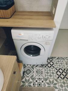 uma máquina de lavar roupa na casa de banho com piso em azulejo em Beau duplex familial avec jardin clôturé em Douvaine