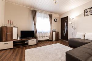a living room with a couch and a flat screen tv at Cozy, quiet & family friendly in Arad in Arad