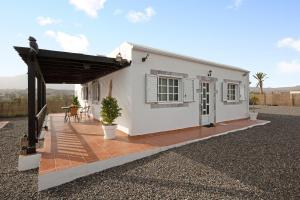 a white house with a porch and a patio at Casa Majos in Tesejerague