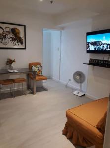 uma sala de estar com um sofá e uma televisão de ecrã plano em Staycation at Azure by Melissa em Manila