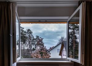 une fenêtre avec vue sur une maison dans l'établissement Motel Zur Dachsbaude, à Wandlitz