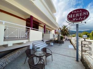 a restaurant with a table and chairs and a sign at Villa Meresi - Thassos Town Center in Limenas