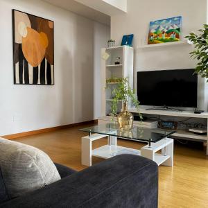 a living room with a glass coffee table and a television at Apartamento Central Antero de Quental in Ponta Delgada +16 photos