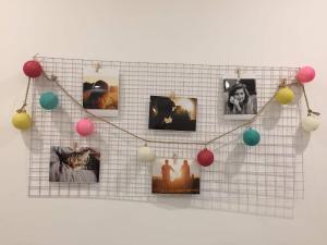 a string of christmas lights on a wall with pictures at Vinhome Grand Park Homestay-HappyStay in Gò Công +40 photos