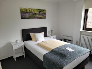 a bedroom with a bed with a blanket and a window at Kurparkhotel-Gemünd in Gemünd