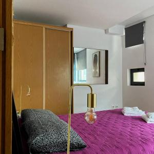 a bedroom with a purple bed with a lamp at Apartamento Central Antero de Quental in Ponta Delgada