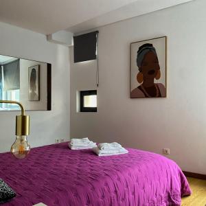 ポンタ・デルガダにあるApartamento Central Antero de Quentalのベッドルーム1室(壁に絵画が描かれた紫色のベッド1台付)