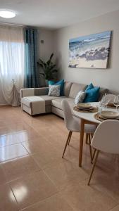 sala de estar con sofá y mesa en Casa Esmeralda, en Corralejo