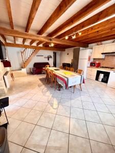 uma cozinha com mesa e cadeiras num quarto em Gîte Le Rouge Queue 3 étoiles em Fresnes