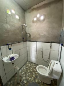 a bathroom with a toilet and a sink at OYO Home 90737 Disan Baang Kiulu in Ranau