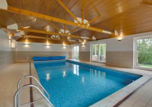 a large swimming pool in a building with a ceiling at Ketlam View The Old Coach House in Pentney