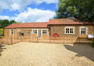 a brick house with a fence in front of it at Ketlam View The Old Coach House in Pentney