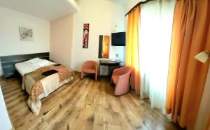 Habitación de hotel con cama, escritorio y silla en Cabana Stejarul en Botoşani