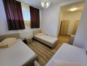 Cette petite chambre comprend 2 lits et une fenêtre. dans l'établissement Cabana Stejarul, à Botoşani