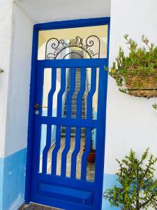 uma porta azul em frente a uma casa em Chez abdelilah em Oualidia