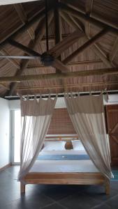 a bed in a room with a ceiling fan at Brahmanhut - Eco Hut experience in harmony with nature, wellbeing and spirit in Bain Boeuf