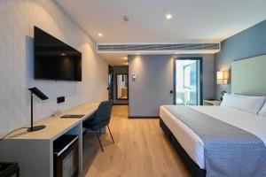 a hotel room with a bed and a desk at Catalonia La Maquinista in Barcelona