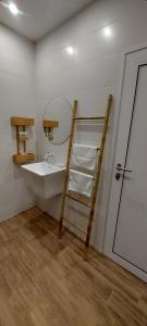 a bathroom with a sink and a ladder next to a mirror at Релакс Хисаря 2 in Hisarya