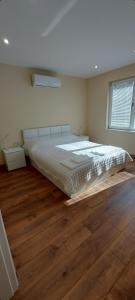 a bedroom with a large bed and a wooden floor at Релакс Хисаря 2 in Hisarya