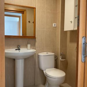 een badkamer met een toilet, een wastafel en een spiegel bij Apartamento Paris I in Miami Platja