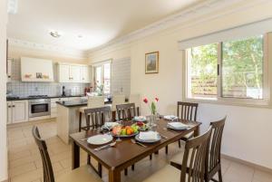 kuchnia i jadalnia ze stołem i krzesłami w obiekcie Villa Andree w mieście Paralimni