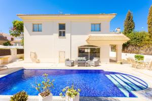 a villa with a swimming pool in front of a house at Villa Andree in Paralimni