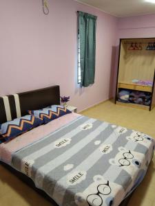 1 dormitorio con 1 cama grande y edredón azul en QQ Homestay en Ipoh