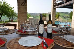 una mesa con copas de vino y botellas de vino. en La casa nella Vigna, en Montegranaro