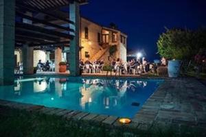 a swimming pool in front of a house at night at La casa nella Vigna in Montegranaro