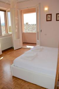 1 cama blanca grande en una habitación con ventana en La casa nella Vigna, en Montegranaro