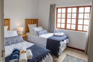 a bedroom with two beds and a window at Beachfront Accommodation in Port Alfred