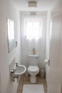 a white bathroom with a toilet and a sink at Beachfront Accommodation in Port Alfred