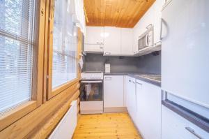 列維的住宿－Reininlaakso Ainola，厨房配有白色橱柜和窗户。