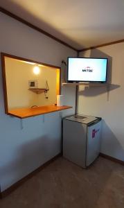um quarto com uma mesa e um ecrã na parede em M&M ll em Comodoro Rivadavia