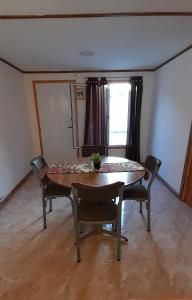 ein Esszimmer mit einem Tisch, Stühlen und einem Fenster in der Unterkunft M&M ll in Comodoro Rivadavia
