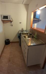 a small kitchen with a sink and a microwave at M&M ll in Comodoro Rivadavia