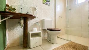 uma casa de banho com um WC e uma cabina de duche em vidro. em CÉU DE AGARTHA Retiros e Vivências em Alto Paraíso de Goiás