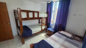 sypialnia z 2 łóżkami piętrowymi i oknem w obiekcie Bravo Surf Camp Punta Rocas w mieście Punta Negra