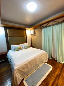 a bedroom with a large white bed in a room at Tagum Mini Hotel By Tripleview residences in Tagum