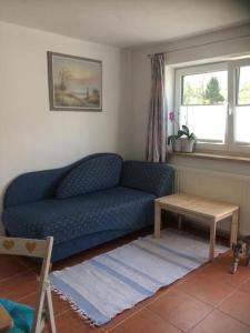 uma sala de estar com um sofá azul e uma mesa em Klein aber fein im Herzen des Pinzgau em Piesendorf
