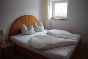 a bed with white sheets and pillows in a room at Klein aber fein im Herzen des Pinzgau in Piesendorf