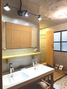 a bathroom with a sink and a mirror at Swallows Hostel in Xiaoliuqiu