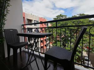 een balkon met 2 stoelen en een tafel bij Condo Azur Suites E507 near Airport, Netflix, Stylish, Cozy with swimming pool in Lapu Lapu City