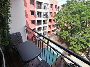 einen Balkon mit einem Stuhl und Blick auf ein Gebäude in der Unterkunft Condo Azur Suites E507 near Airport, Netflix, Stylish, Cozy with swimming pool in Lapu Lapu City