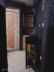 uma cozinha com uma parede preta e um frigorífico com uma esfregona em Monique Furnished Studio apartment -South B em Nairobi