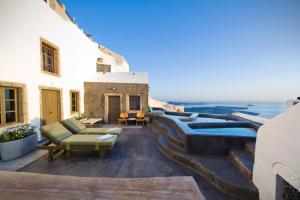 un patio en la azotea con vistas al océano en Sophia Luxury Suites, en Imerovigli